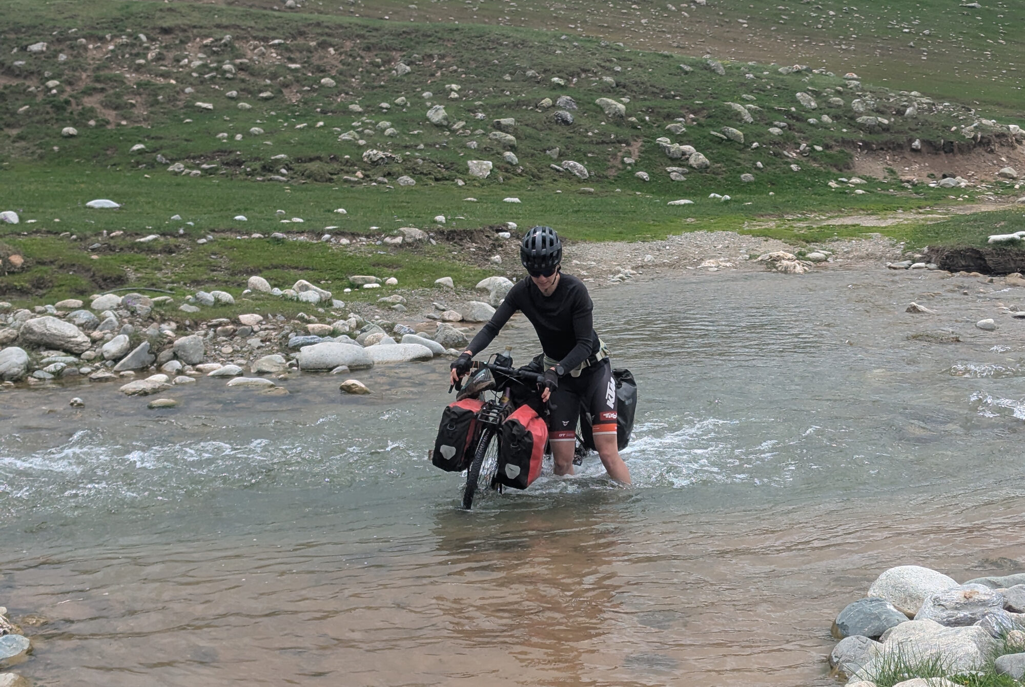 Cyclist crossing a river in Kazakhstan